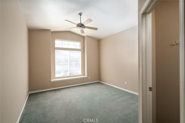 spare room with lofted ceiling, baseboards, dark colored carpet, and a ceiling fan