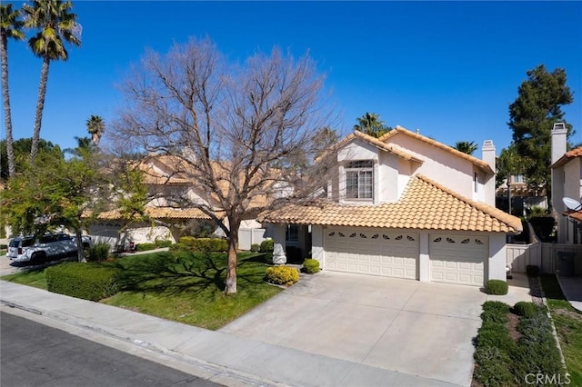 view of front of home with concrete driveway, a tile roof, an attached garage, and stucco siding