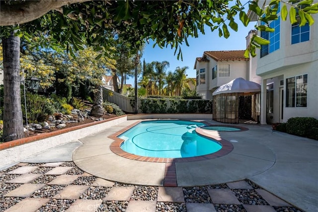 view of pool featuring an in ground hot tub, a patio, fence, and a fenced in pool