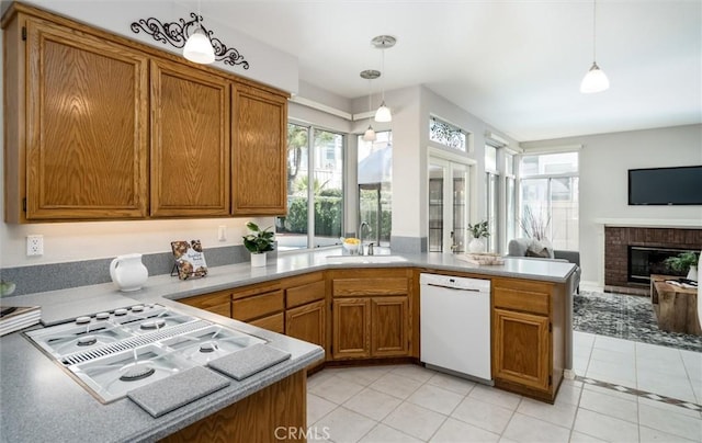 kitchen with dishwasher, hanging light fixtures, a sink, and light countertops