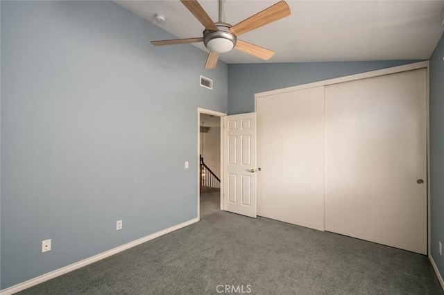 unfurnished bedroom with carpet floors, lofted ceiling, a closet, visible vents, and baseboards