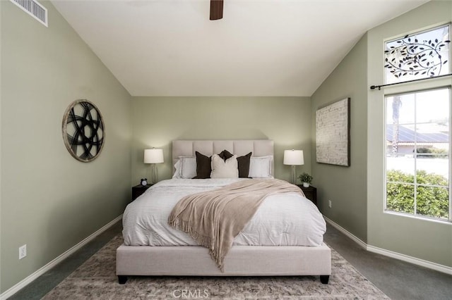 bedroom featuring lofted ceiling, multiple windows, visible vents, and baseboards