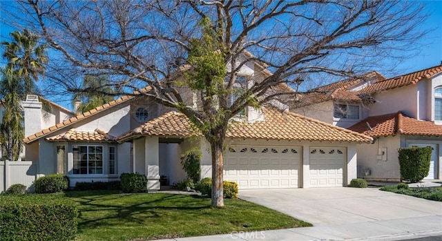 mediterranean / spanish home with concrete driveway, stucco siding, a tile roof, an attached garage, and a front yard