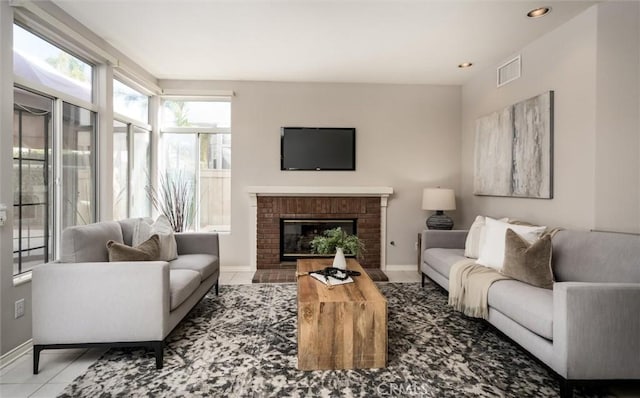 living room with light tile patterned flooring, recessed lighting, a fireplace, visible vents, and baseboards