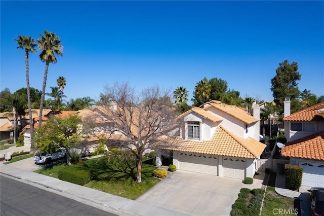 view of front of home featuring an attached garage, a tile roof, concrete driveway, a residential view, and stucco siding