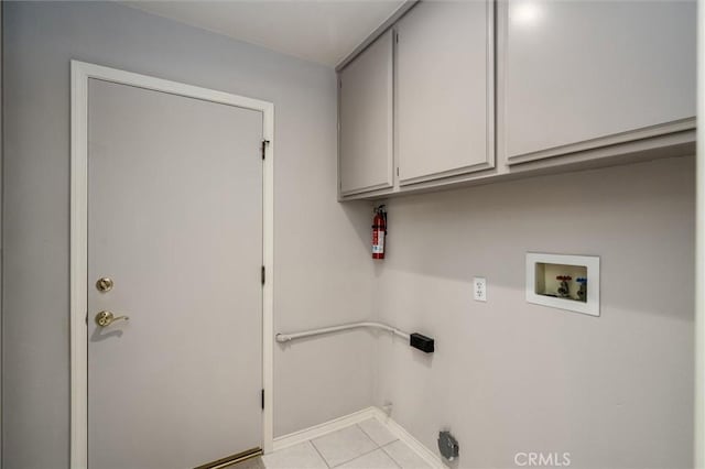 laundry area with light tile patterned floors, hookup for a washing machine, cabinet space, and baseboards