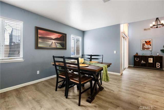 dining room with hardwood / wood-style flooring and a chandelier