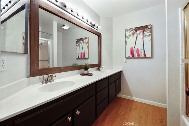 bathroom featuring hardwood / wood-style flooring, vanity, and an enclosed shower