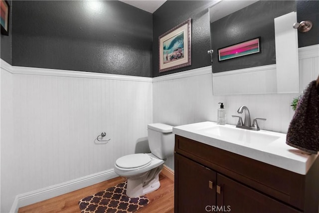 bathroom with vanity, wood-type flooring, and toilet