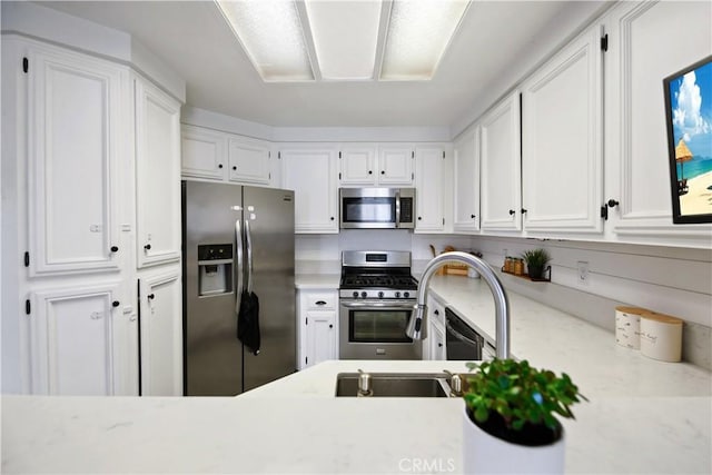 kitchen featuring appliances with stainless steel finishes, sink, and white cabinets