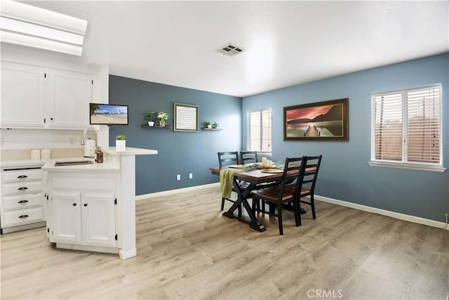 dining room featuring sink and light wood-type flooring