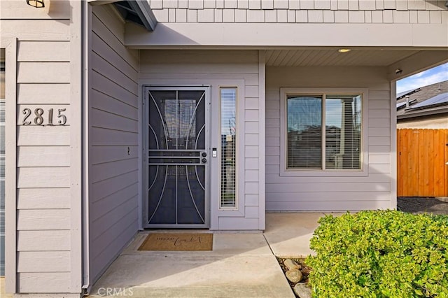 view of exterior entry featuring fence