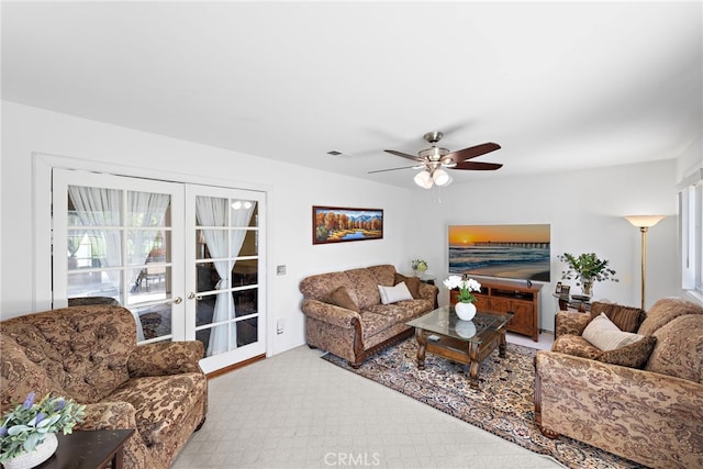 living area with french doors, visible vents, and ceiling fan