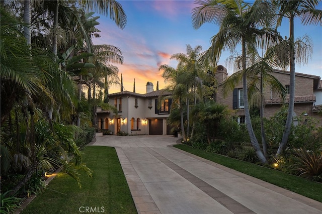 mediterranean / spanish-style house with a yard and a garage