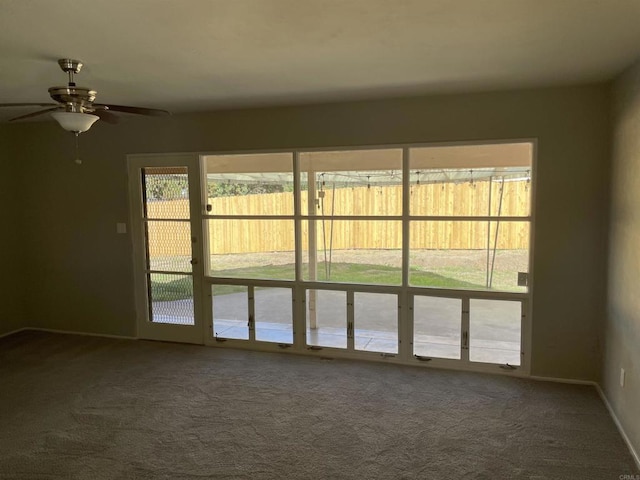 carpeted empty room featuring baseboards