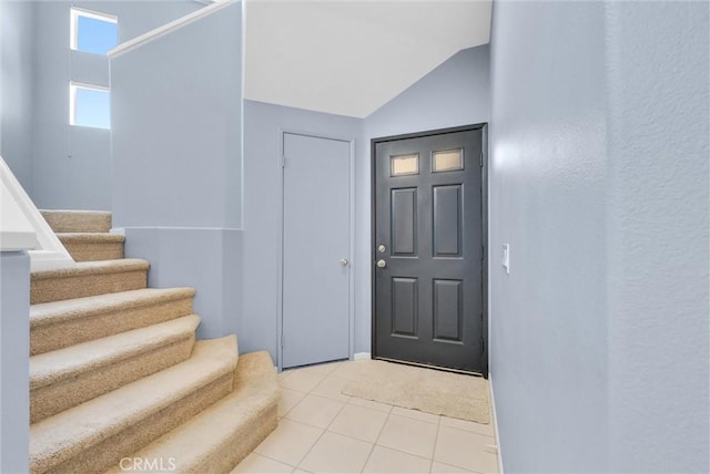 tiled entryway with lofted ceiling