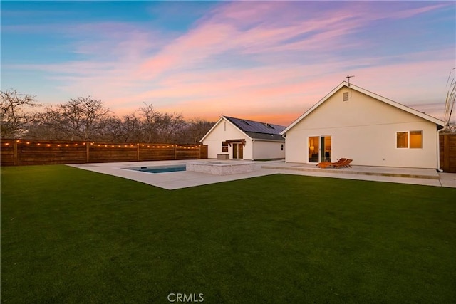 back of property with a fenced backyard, a patio, and a yard