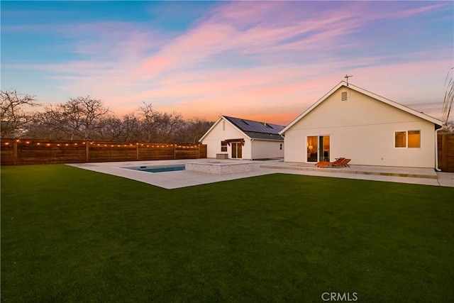 9243 Turner Ln, Durham, CA 95938 - back of property at dusk with an in-ground hot tub, a patio, a fenced backyard, and stucco siding