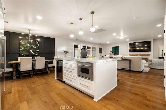9243 Turner Ln, Durham, CA 95938 - kitchen with wine cooler, light wood-style floors, white cabinets, light countertops, and recessed lighting