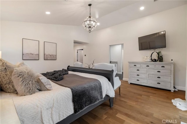 bedroom featuring a chandelier, recessed lighting, baseboards, and wood finished floors