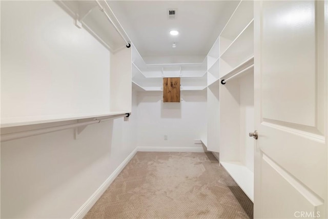 walk in closet featuring visible vents and light colored carpet