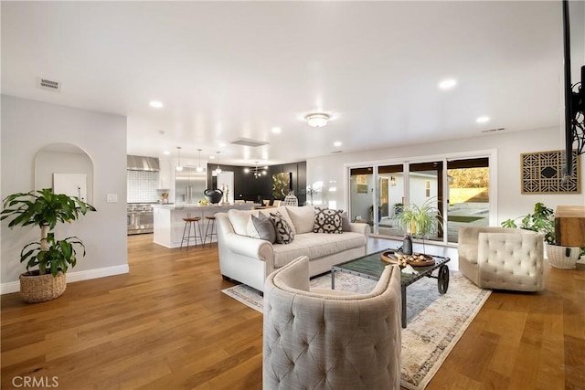 living area featuring light wood-style flooring, visible vents, baseboards, and recessed lighting