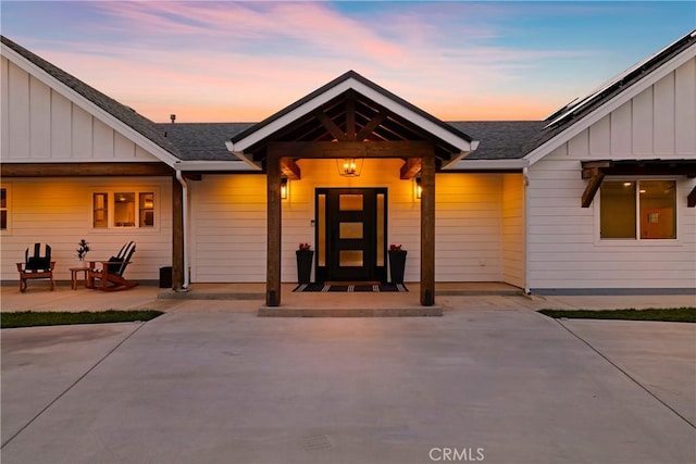 9243 Turner Ln, Durham, CA 95938 - exterior entry at dusk featuring board and batten siding and a shingled roof