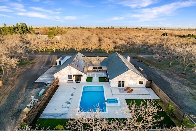 view of swimming pool featuring a fenced backyard, a pool with connected hot tub, and a patio