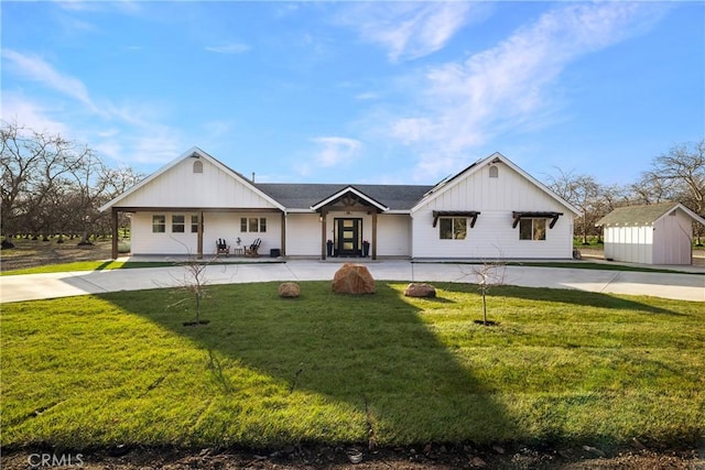 view of front of property featuring board and batten siding, concrete driveway, and a front lawn