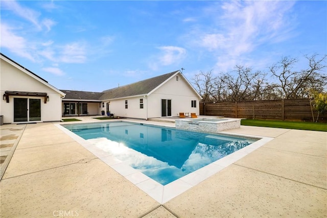 view of swimming pool with a pool with connected hot tub, a patio, and fence