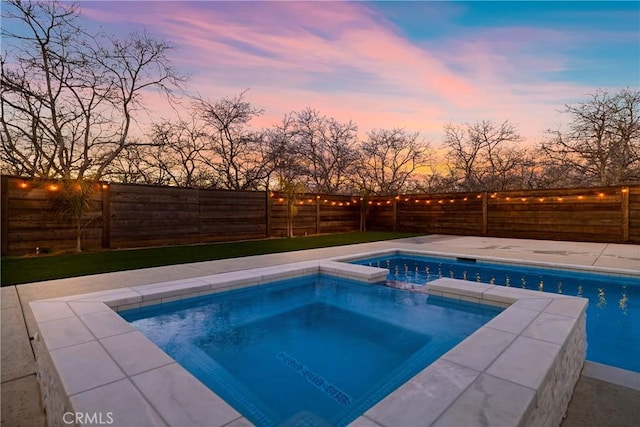 pool at dusk with a fenced in pool, a fenced backyard, and an in ground hot tub