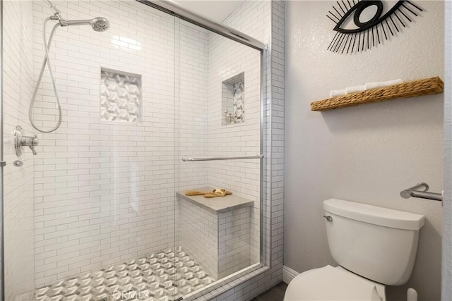 bathroom with a stall shower and toilet