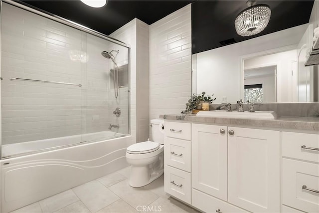 full bathroom featuring toilet, tile patterned flooring, bath / shower combo with glass door, and vanity