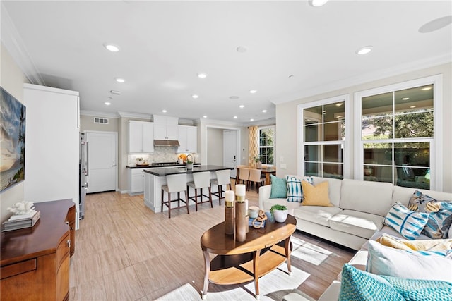living room with recessed lighting, crown molding, and visible vents