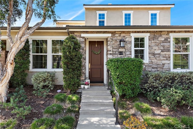 view of front facade featuring stucco siding and stone siding