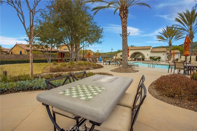 view of patio featuring fence and a community pool