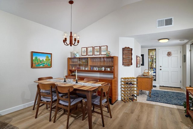 dining room featuring light hardwood / wood-style floors, a chandelier, and lofted ceiling