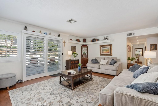 living room with hardwood / wood-style flooring and crown molding