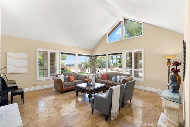 living area with high vaulted ceiling and baseboards