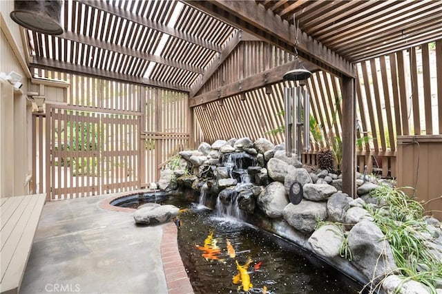 view of patio featuring a pergola and a garden pond