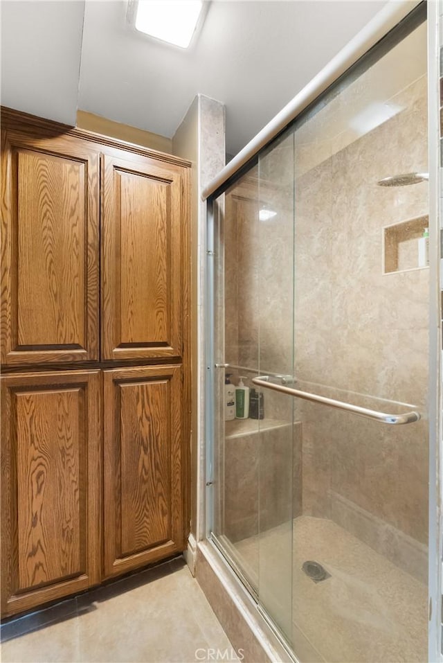 bathroom with tile patterned flooring and a shower stall