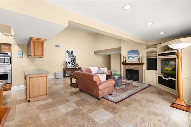 living area featuring visible vents, baseboards, recessed lighting, vaulted ceiling, and a fireplace