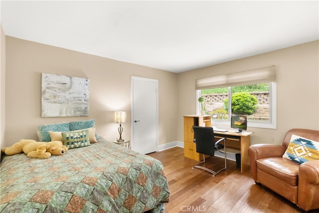 bedroom featuring baseboards and wood finished floors