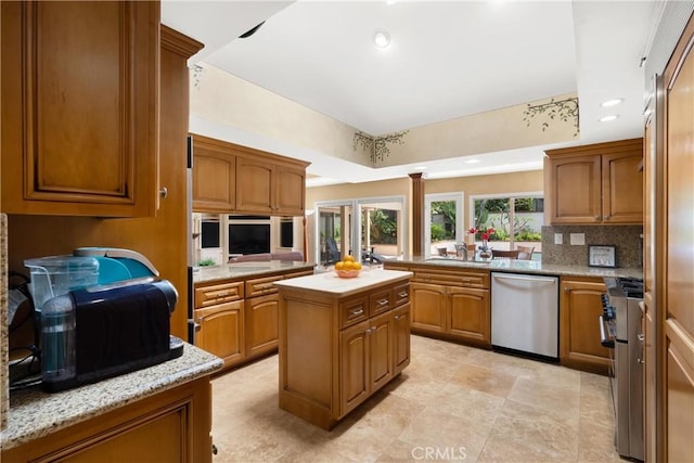 kitchen featuring stainless steel appliances, decorative backsplash, and brown cabinetry