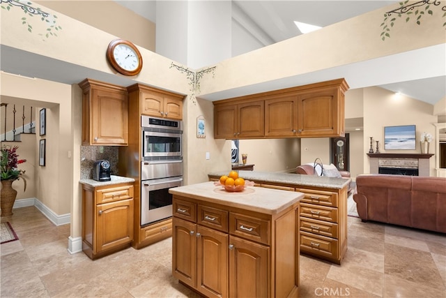kitchen with a kitchen island, light countertops, oven, a warming drawer, and high vaulted ceiling