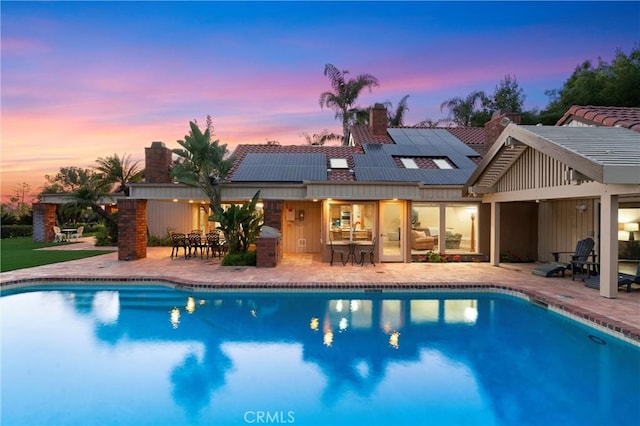 pool with outdoor dining space and a patio