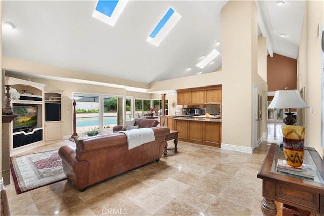 living room with a skylight, high vaulted ceiling, and baseboards