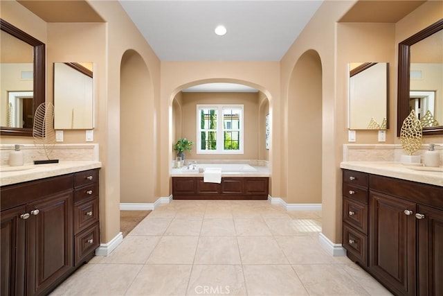 bathroom with tile patterned flooring, vanity, and a bathtub