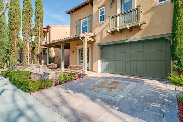 view of front of property featuring a garage and a balcony