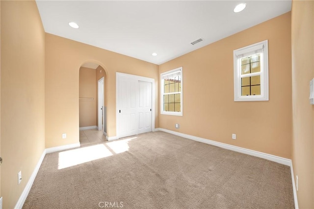 unfurnished bedroom featuring light carpet and a closet